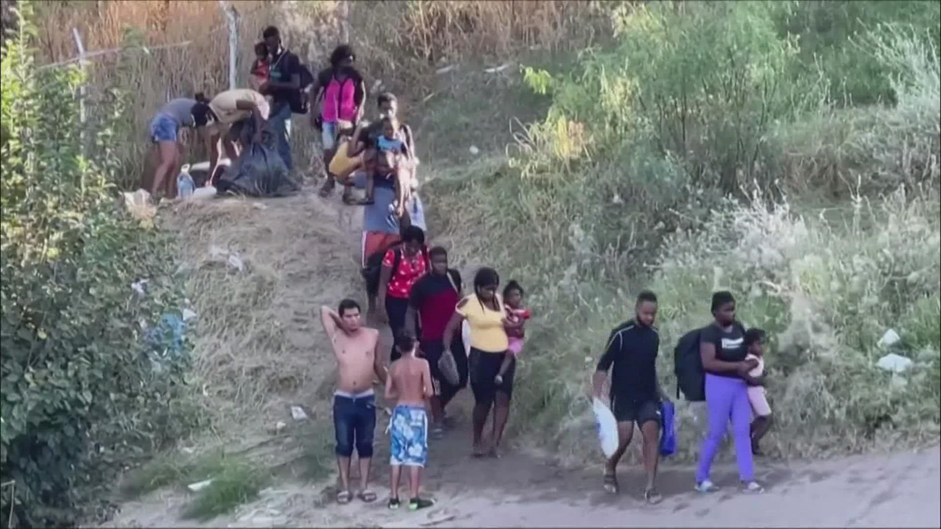 Migrants are walking through the knee-deep waters of the Rio Grande and building makeshift tents out of sticks.