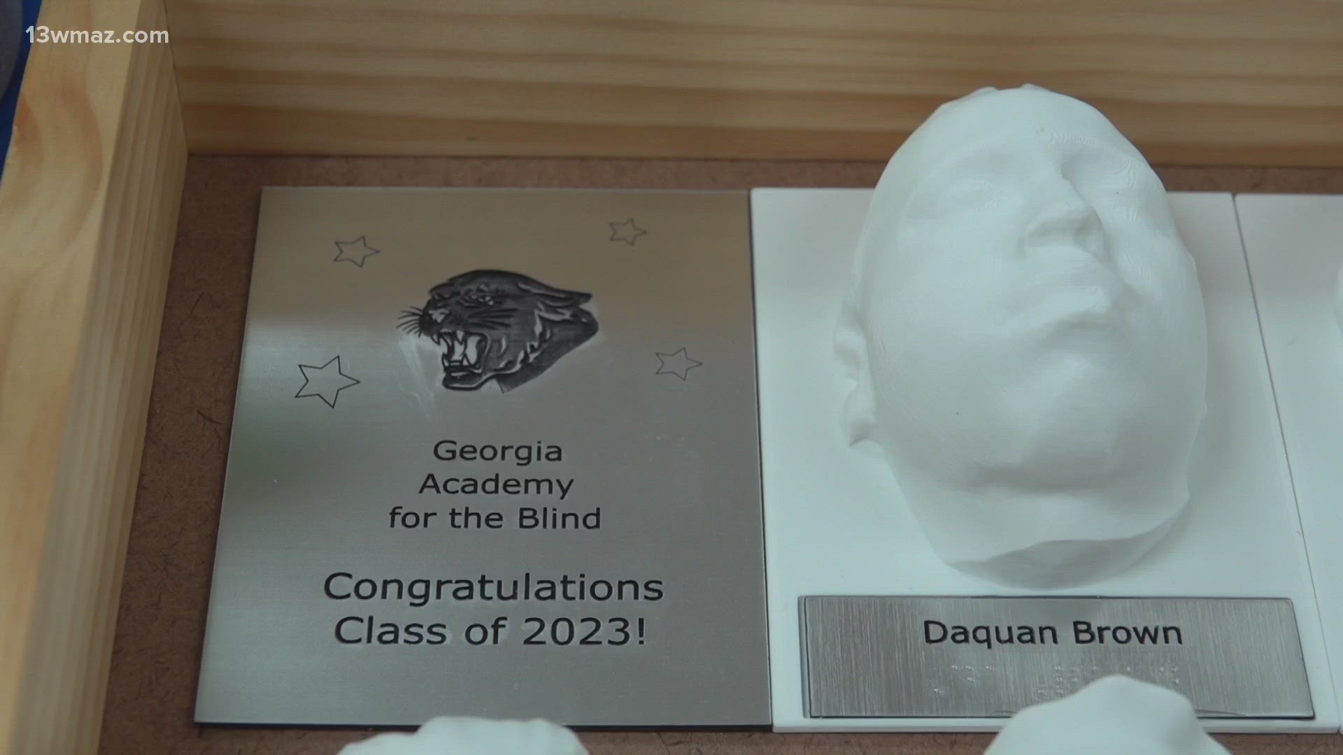 The yearbooks were wooden boxes with a 3D printed face model of each student and their names printed in braille.