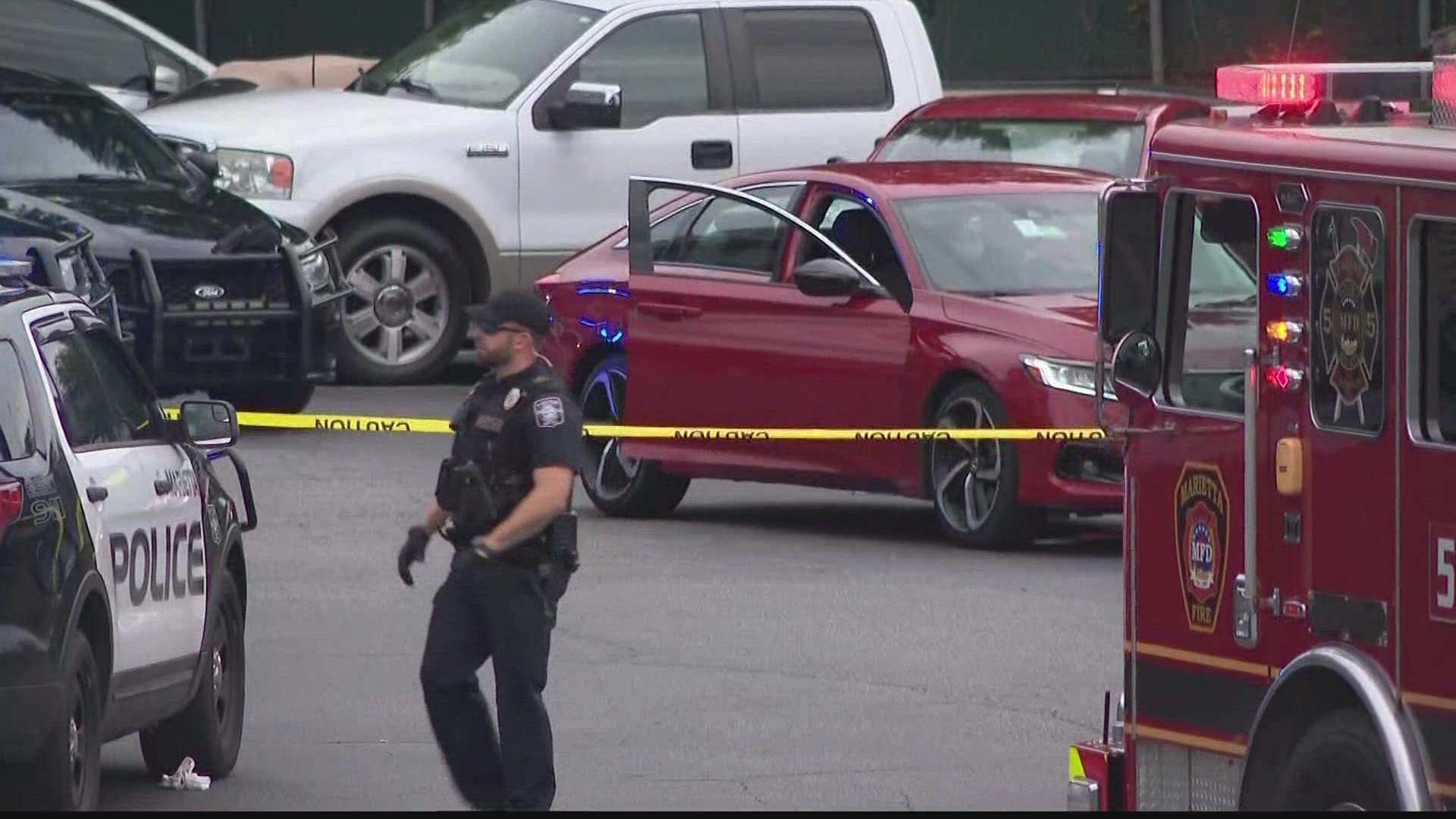 A man is dead and an officer injured after a shooting broke out in the parking lot of a Motel 6 in Marietta Thursday evening, according to police.