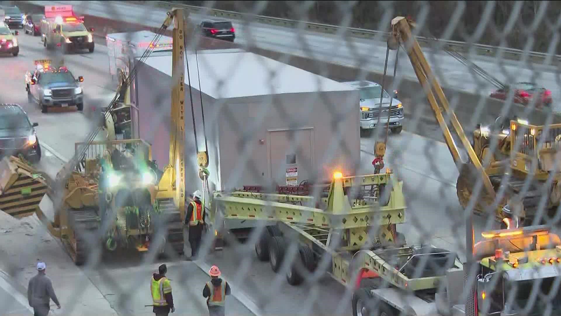 The trailer is being slowly towed off the highway creating traffic in the area.