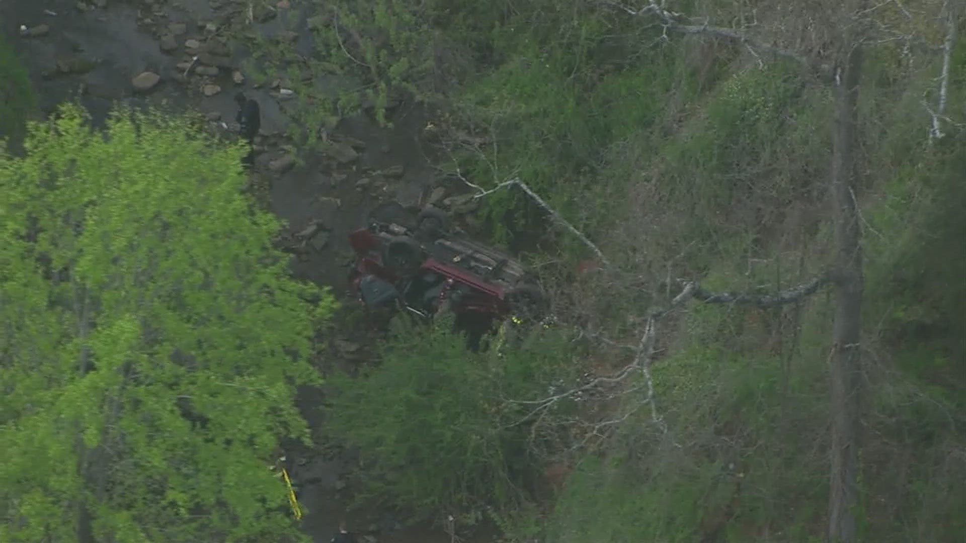 11Alive's SkyTracker is over the scene where a car can be seen flipped over in a creek with what appears to be at least a dozen first responders on scene.