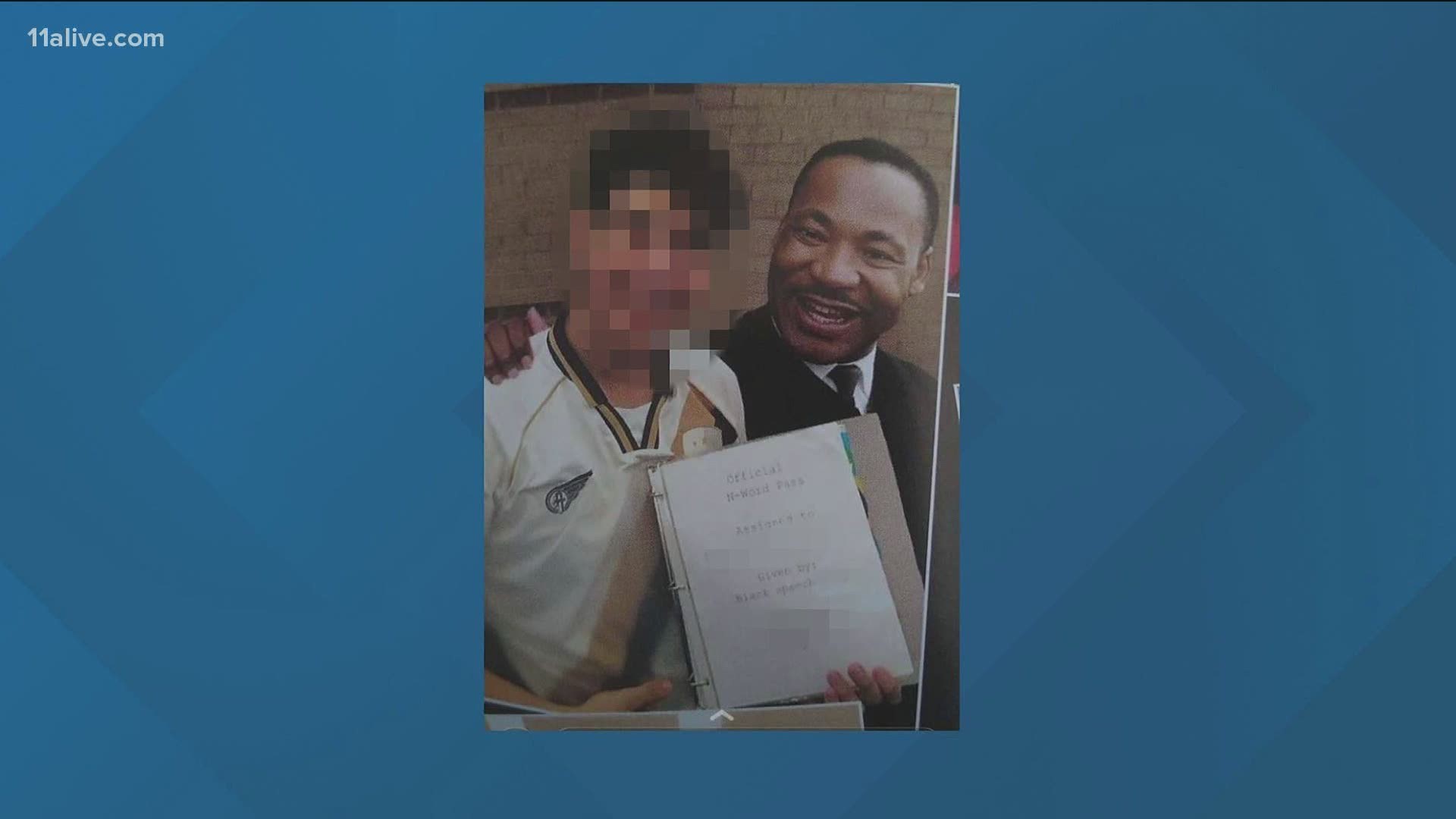 The photograph shows a student posing with Dr. Martin Luther King Jr., while holding a notebook with a document that reads "Official N-word Pass."
