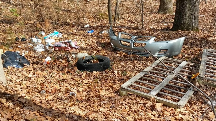 No Dumping' sign surrounded by hundreds of tires. And Neighbors