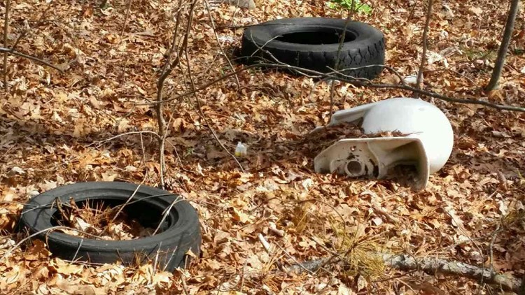 No Dumping' sign surrounded by hundreds of tires. And Neighbors