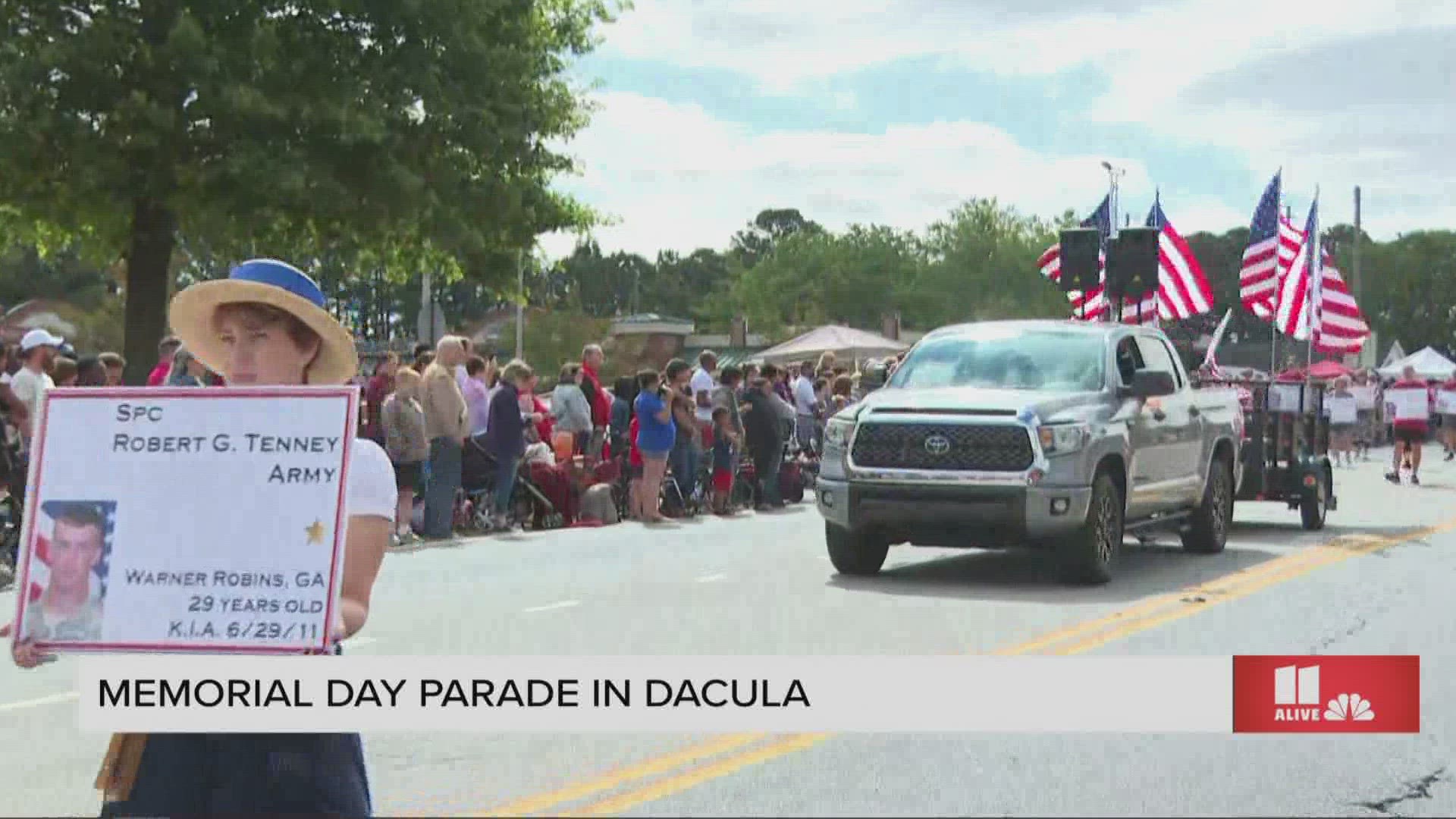 Each year, the residents of Dacula carry signs with photos and names of those they have lost.
