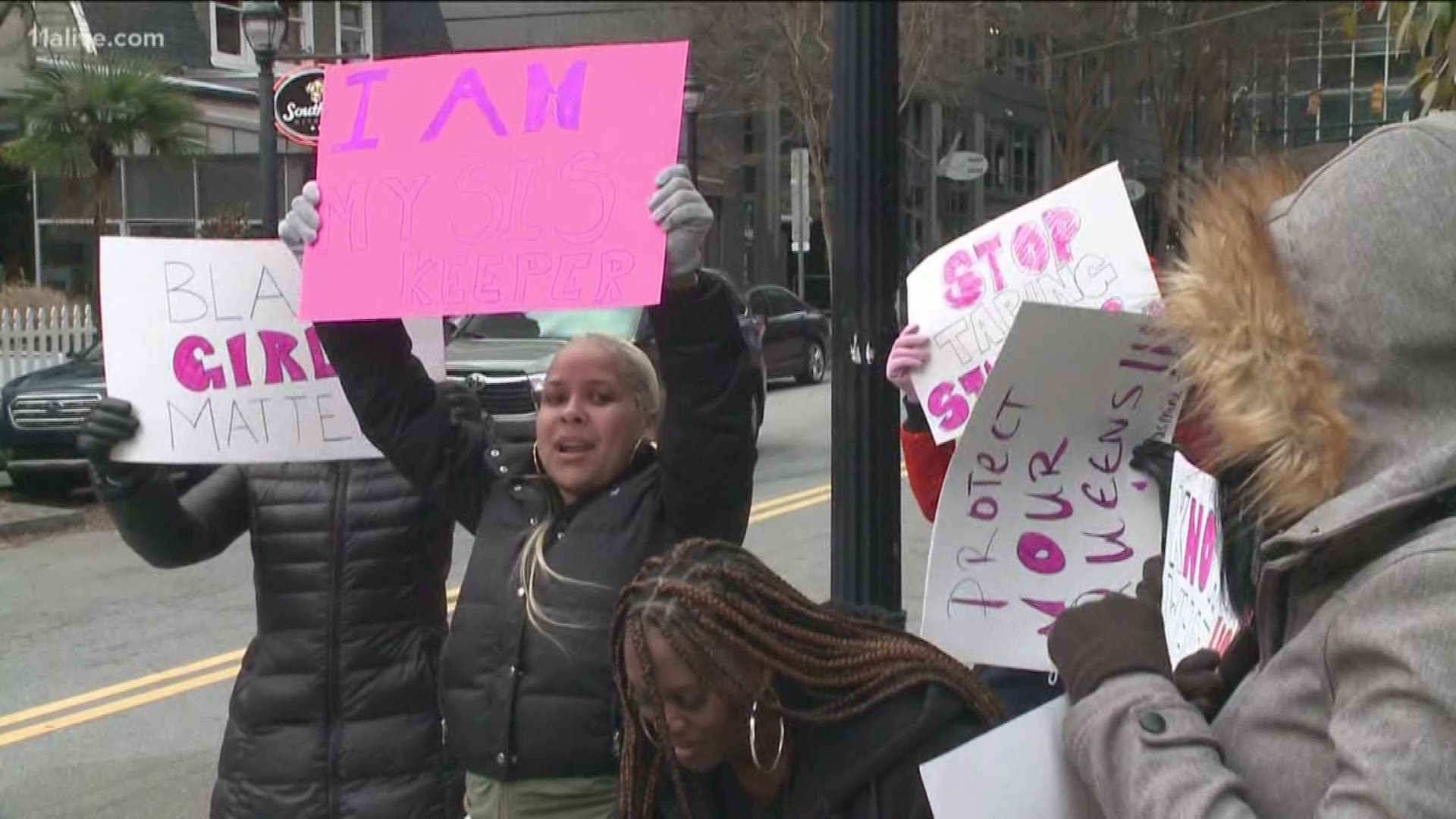 Protesters held signs outside of the club Tuesday.