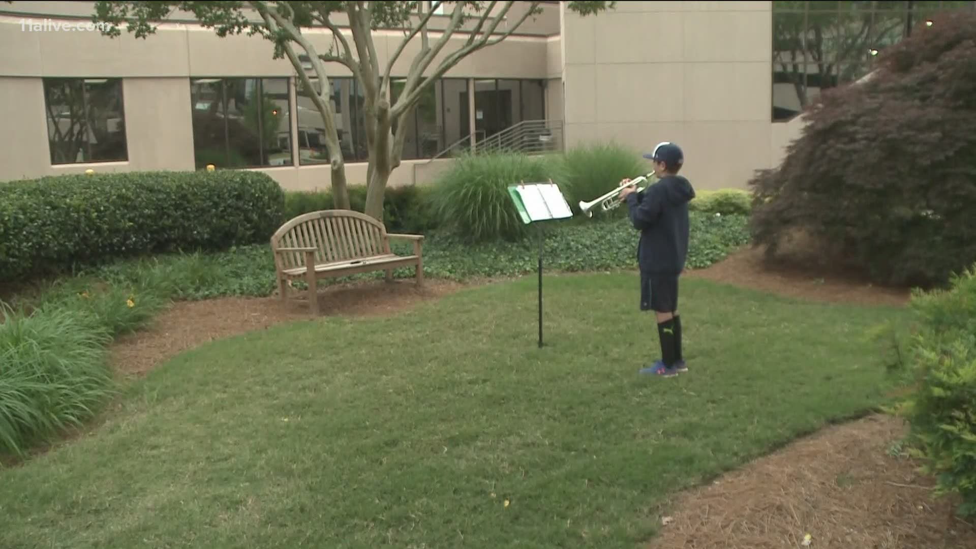 For almost 30 days, a 6th grader brings his trumpet to Emory Hospital in Decatur to play for workers during shift change.
