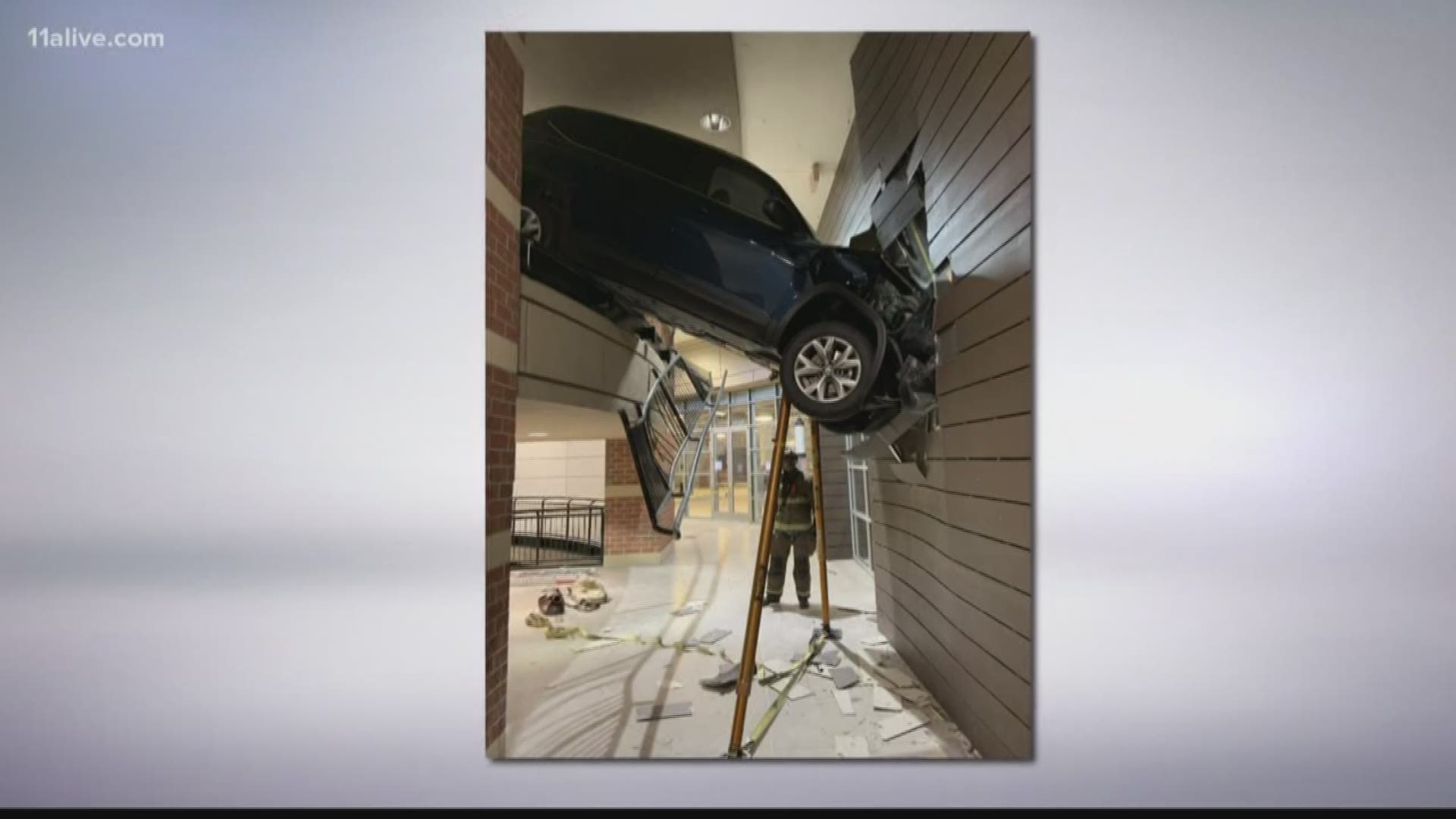 A woman drove her SUV off the second story of a Buckhead parking deck and through a wall, leaving her car suspended about 10 feet off the ground.