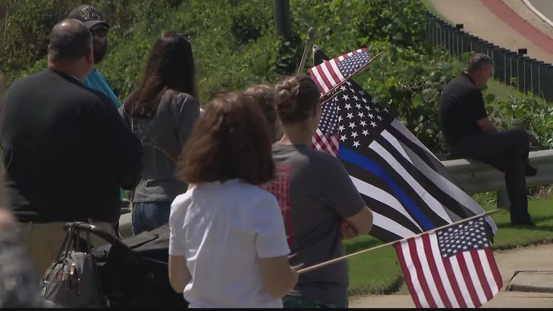 A sea of blue, a wave of emotions, and flags as far as the eye could see filled the route a fallen hero took to his final resting place.