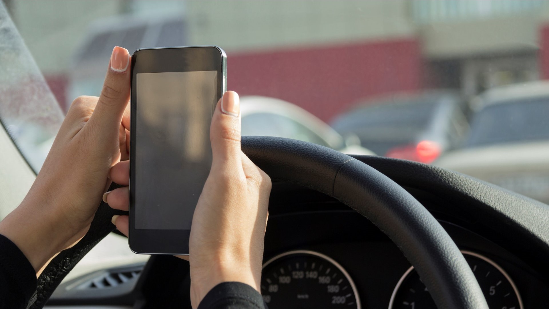 The proposed legislation would allow drivers to hold their cell phones at stoplights.