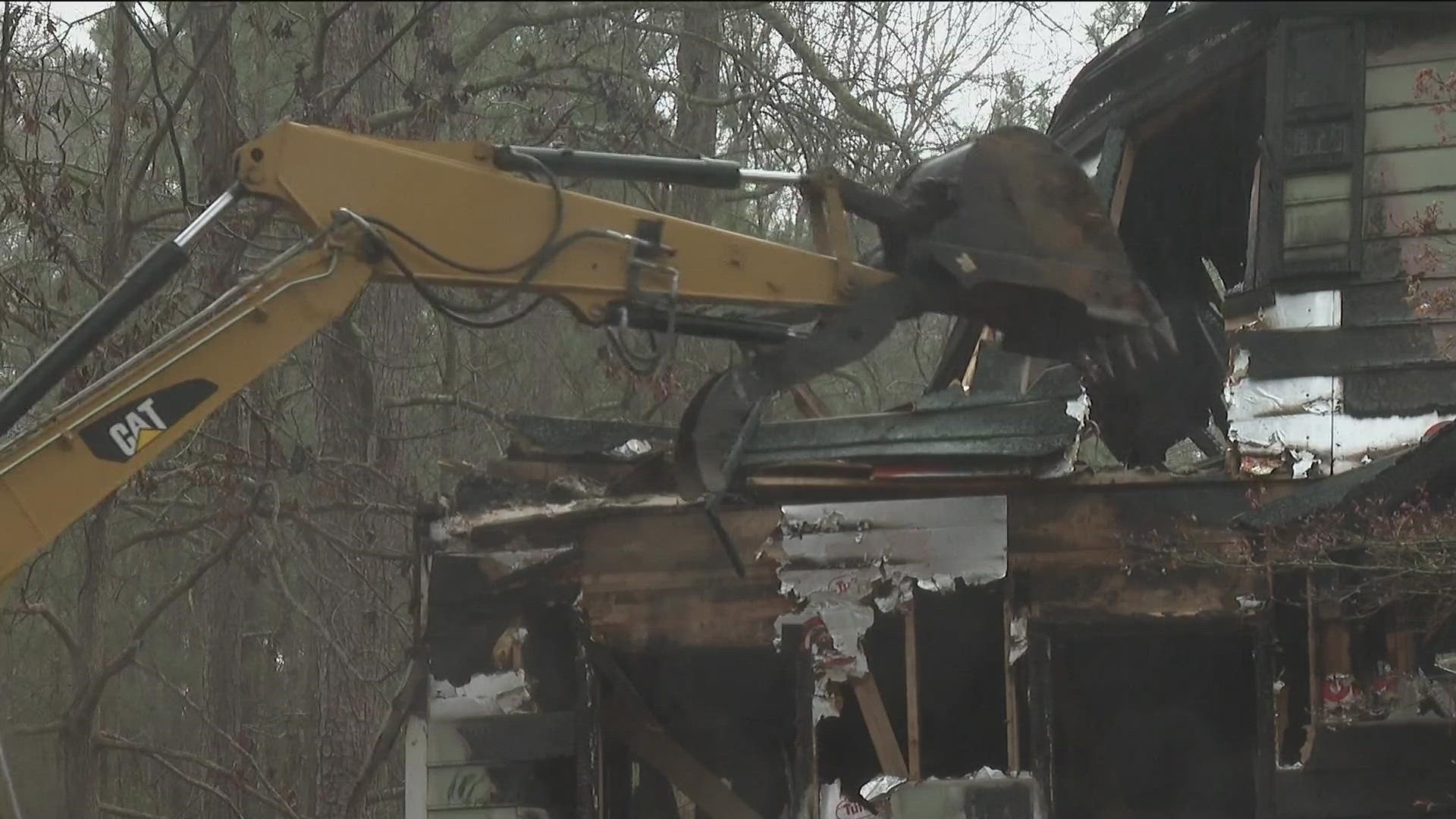 A South Fulton home destroyed by arson that killed four people, including the homeowner last October, was demolished Thursday morning.