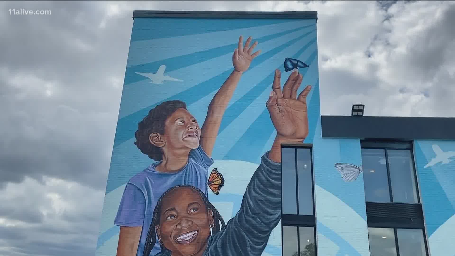 A mural in Hapeville entitled "We Give Each Other the World" celebrates the lives of undocumented immigrants.