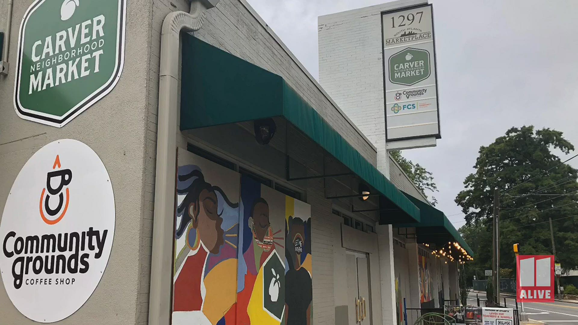 After being vandalized, this neighborhood's only grocery store, The Carver Market, is painting a mural on the plywood and the neighbors are helping.