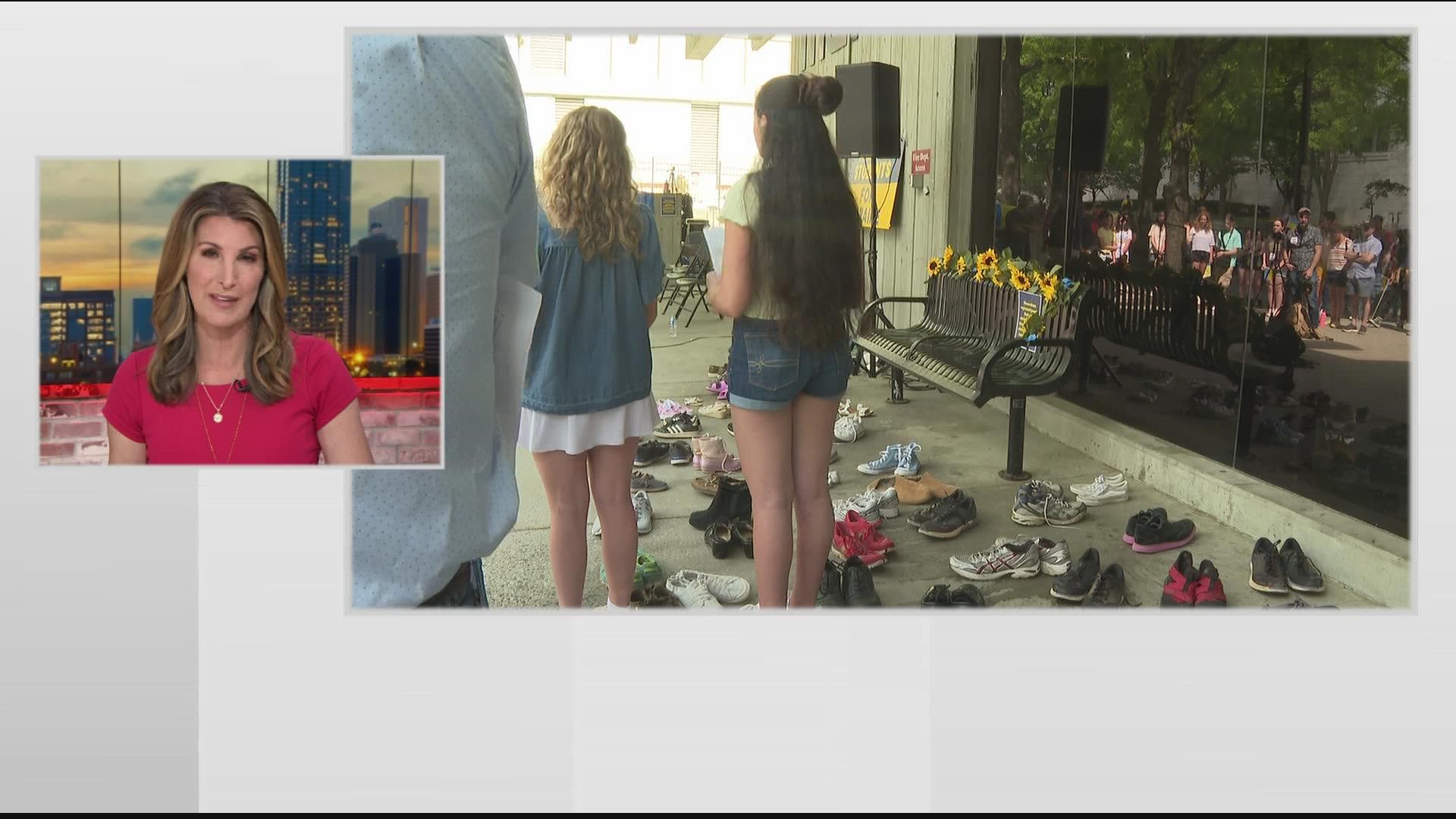 High school students placed 300 donated shoes outside the Midtown MARTA station to remember the 148 people killed or injured during the attack.