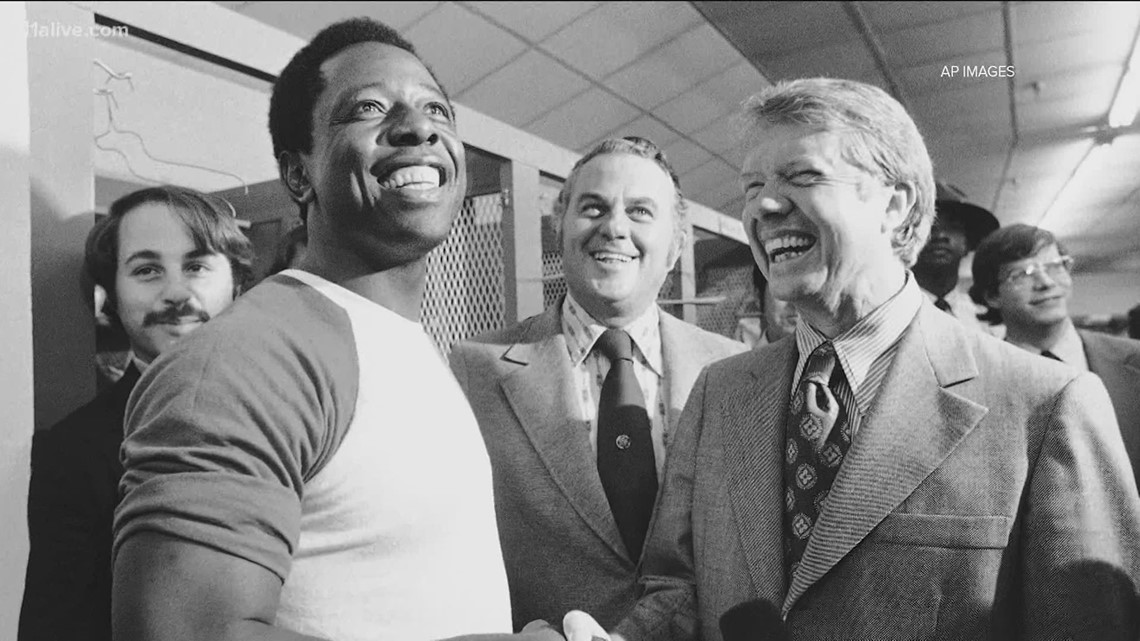 FILE - In this Sept. 30, 1969, file photo, a Major League Baseball 100th  anniversary patch is shown on the uniform of Atlanta Braves team captain  Hank Aaron, left, as he watches