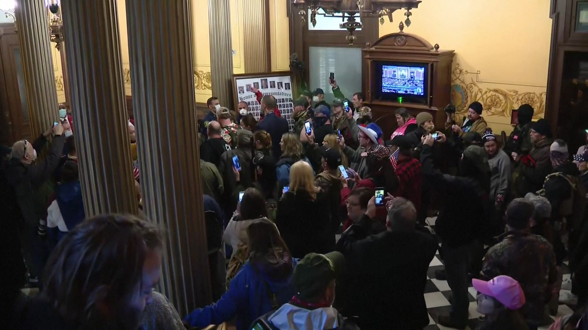 Demonstrators pushed their way into the Michigan State Capitol building in Lansing on Thursday as lawmakers were voting on extending a state of emergency.