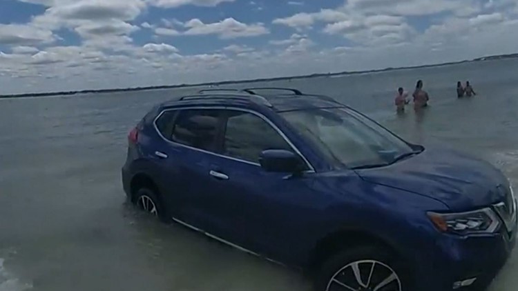 Car stuck on beach after nearly hitting families | Police video